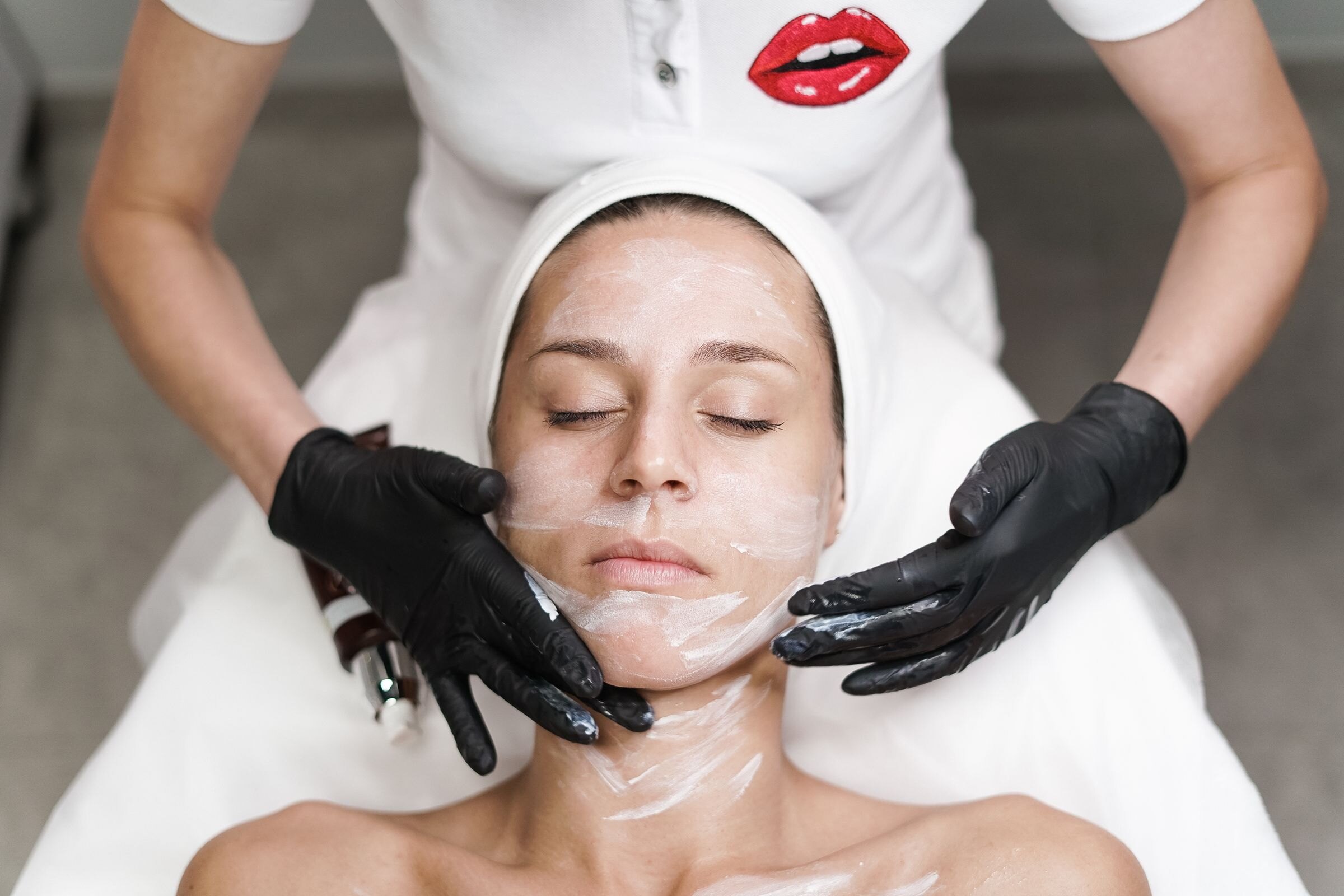 Schoonheidsspecialist brengt een masker aan
